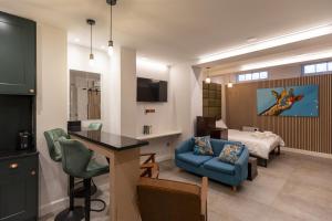 a living room with a blue couch and a bedroom at London Boutique Apartments in London