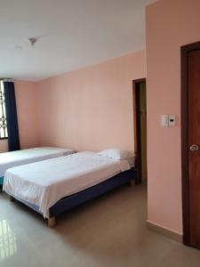 sypialnia z dwoma łóżkami i drzwiami w obiekcie El Sol Dorado w mieście Tonsupa