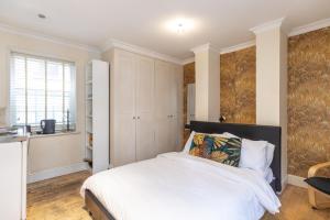 a bedroom with a white bed and a window at London Boutique Apartments in London