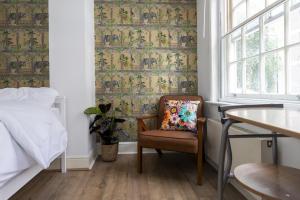 a bedroom with a chair and a bed and a window at London Boutique Apartments in London