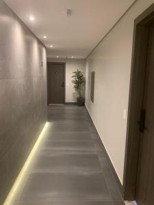 an empty hallway with a potted plant in the middle at Noroeste Easy by CentoEdez in Brasilia