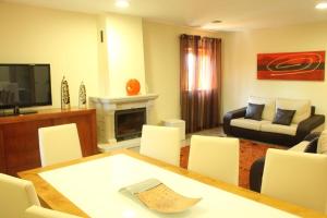 Una sala de estar con una mesa y sillas y un sofá. en Villa 315, en Laundos