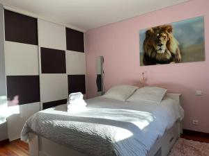 um quarto com uma cama com uma imagem de leão na parede em La maison de pierres onches em Anduze