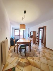 - une salle à manger et un salon avec une table et des chaises dans l'établissement La Dimora delle Dolomiti - Pinzolo, à Pinzolo