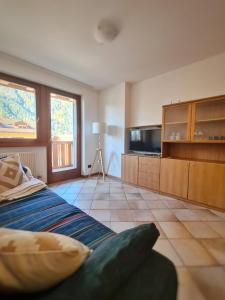 a living room with a bed and a television at La Dimora delle Dolomiti - Pinzolo in Pinzolo