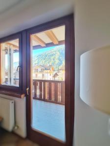 a glass door with a view of a balcony at La Dimora delle Dolomiti - Pinzolo in Pinzolo