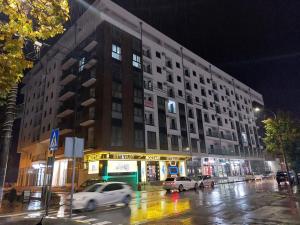 een groot gebouw in een stadsstraat 's nachts bij Akvarel apartman in Jagodina