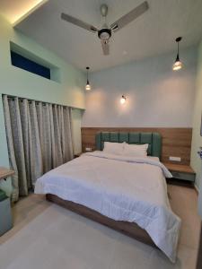 Green Villa في أودايبور: غرفة نوم بسرير كبير ومروحة سقف