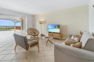 sala de estar con sofá y TV en VILLA HOLIDAYS - Piscine + Vue sur mer + Accès randonnée, en Le Moule