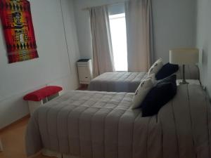 a bedroom with two beds and a window at Tu lugar en Rada Tilly in Rada Tilly +15 photos