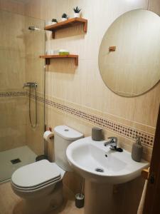 een badkamer met een toilet, een wastafel en een spiegel bij ZUBICALM in La Zubia