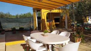 a white table and white chairs on a patio at Casa Eli in L'Ampolla