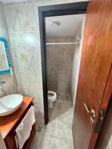 baño con aseo, lavabo y puerta en Cabaña La Tamarita barrio colinas verdes Sierra de los Padres en Mar del Plata