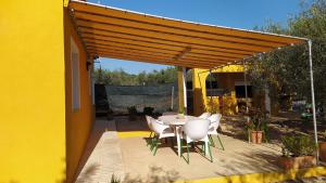 a patio with a table and chairs under awning at Casa Eli in L'Ampolla