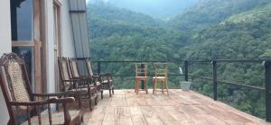 a balcony with chairs and a view of the mountains at Ayu Bliss Elamulla, Mandaramnuwara in Mandaran Newara