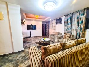 a living room with two couches and a table at Résidence FAMILIA PHOENIX in Douala