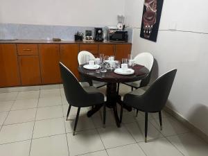 une table dans une cuisine avec des chaises autour de celle-ci dans l'établissement Classic all ensuit 3 bedroom in kisumu town, à Kisumu