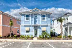 a blue house with palm trees in a parking lot at Margaritaville Cottages Orlando by Rentyl in Orlando