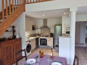 eine Küche mit Tisch und eine Küche mit Treppe in der Unterkunft Villa El Còrrec in Laroque-des-Albères + 17 Fotos
