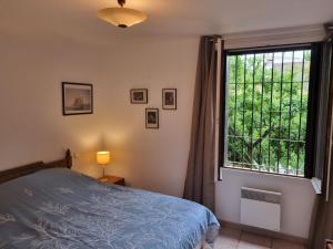 ein Schlafzimmer mit einem Bett und einem großen Fenster in der Unterkunft Villa El Còrrec in Laroque-des-Albères