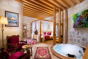 a bedroom with a tub and a bed in a room at Ayazma Cave Hotel in Urgup