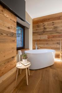 a bath tub in a bathroom with wooden walls at L’Ozio Creativo in Castelnuovo Nigra