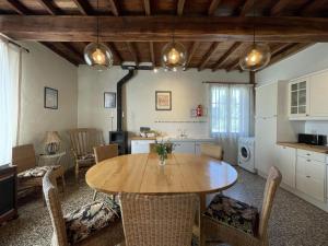 cocina y comedor con mesa de madera y sillas en Maison Lajus en Bassillon-Vauzé