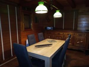 une table à manger avec des chaises bleues et deux lumières dans l'établissement Chalet au calme en Haute Savoie., à Châtillon-sur-Cluses