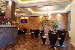 a restaurant with chairs and a brick wall at Casta Diva Boutique Hotel in Korçë
