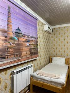 a small room with a bed and a window at Khiva Otabek Hotel in Khiva