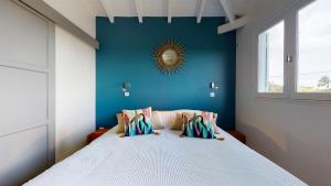 a bedroom with a bed with a blue wall at Les maisons Cane in Sainte-Rose +35 photos