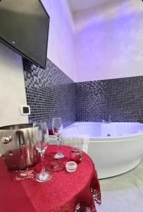 een badkamer met een tafel met wijnglazen en een bad bij Giulia's house Roma in Rome
