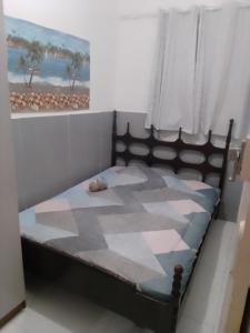 een slaapkamer met een bed met een dekbed erop bij Cantinho da paz in Cabo Frio