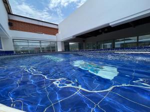 uma piscina com água azul em frente a um edifício em Penthouse San Rafael em San Rafael
