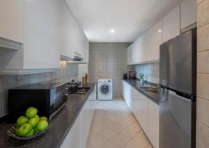 a large kitchen with a washer and dryer in it at Fraser Place Robertson Walk Singapore in Singapore