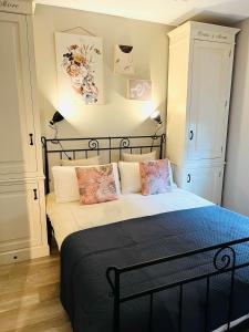 a bedroom with a black bed with pillows on it at Duinenzicht II-Vosseslag De Haan in De Haan
