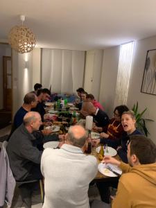 Un groupe de personnes assises autour d'une table à manger dans l'établissement Gite la découverte petit déjeuner offert, au Puy-en-Velay