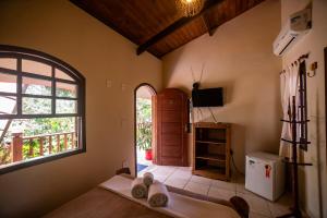 a room with a bed and a tv and a window at Casa da Praia in Paraty