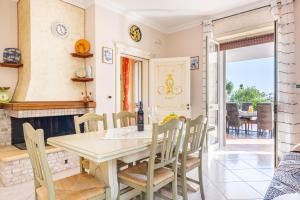 uma sala de jantar com uma mesa e cadeiras e uma lareira em Villa Vanessa em Castrignano del Capo