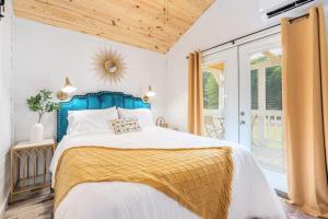 een slaapkamer met een bed met een blauw hoofdeinde bij 7 Le Soleil Retro Tiny House, Boat Parking, Mins to Lake Guntersville, City Harbor in Guntersville