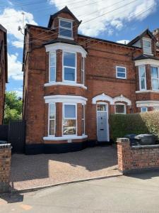 een groot bakstenen gebouw met een witte deur op een straat bij Reservoir Retreat in Birmingham