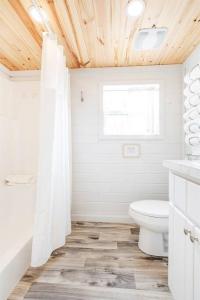 een witte badkamer met een toilet en een raam bij 7 Le Soleil Retro Tiny House, Boat Parking, Mins to Lake Guntersville, City Harbor in Guntersville