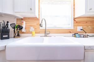 a white sink in a kitchen with a window at 8 All Decked Out, Luxury Tiny House, Boat Parking Mins to Lake Guntersville, Downtown in Guntersville