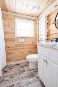 a bathroom with wooden walls and a toilet and a window at 8 All Decked Out, Luxury Tiny House, Boat Parking Mins to Lake Guntersville, Downtown in Guntersville