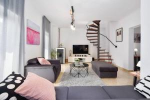 ein Wohnzimmer mit einem Sofa und einer Wendeltreppe in der Unterkunft Villa Batarelo in Sinj