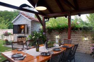 einen Holztisch auf einer Terrasse mit einem Tisch zum Abendessen in der Unterkunft Villa Batarelo in Sinj