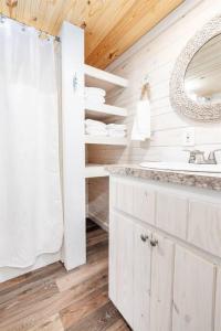 a bathroom with a sink and a mirror at 4 Heron Haus, Luxury Tiny House, Pet Friendly, Mins to Downtown Guntersville in Guntersville +33 photos