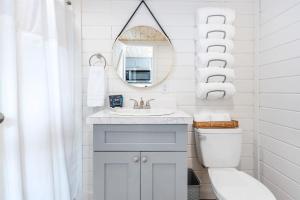 W białej łazience znajduje się umywalka i lustro. w obiekcie 2 Villa D'Azur Luxury Tiny House Mins to Lake Guntersville, Downtown, Firepit w mieście Guntersville