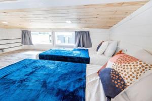 2 łóżka w niewielkim pokoju z drewnianymi sufitami w obiekcie 2 Villa D'Azur Luxury Tiny House Mins to Lake Guntersville, Downtown, Firepit w mieście Guntersville
