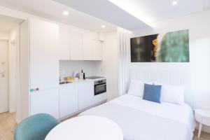 a white room with a bed and a kitchen at FAFEL LITTLE HOUSE - Quinta de Cravaz in Lamego